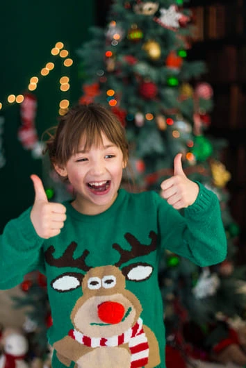 petite fille joyeuse en pull de Noël